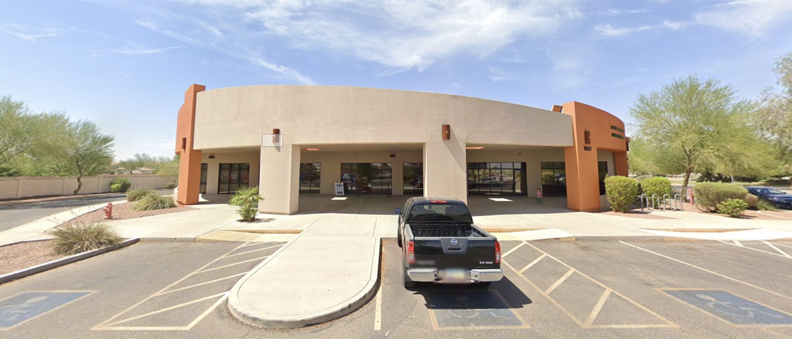 The single-storey office building at 1637 E Monument Plaza Cir, with a covered entrance and parking in front.